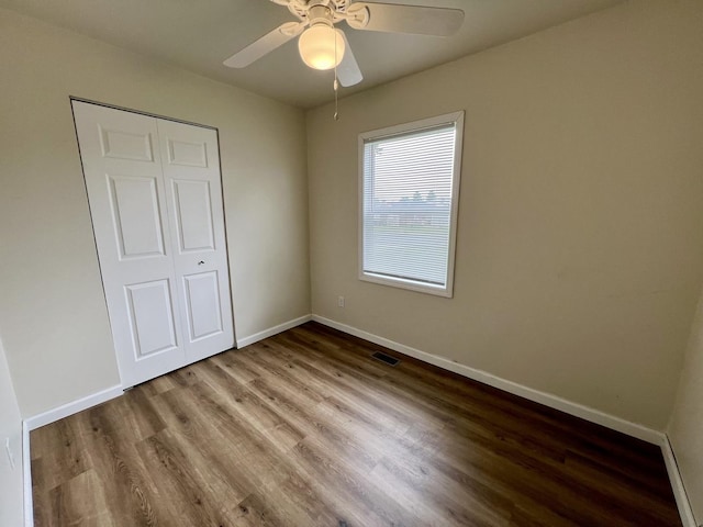 2422 E Washington St, Urbana, IL 61802 - unfurnished bedroom featuring wood finished floors, ceiling fan, and a closet