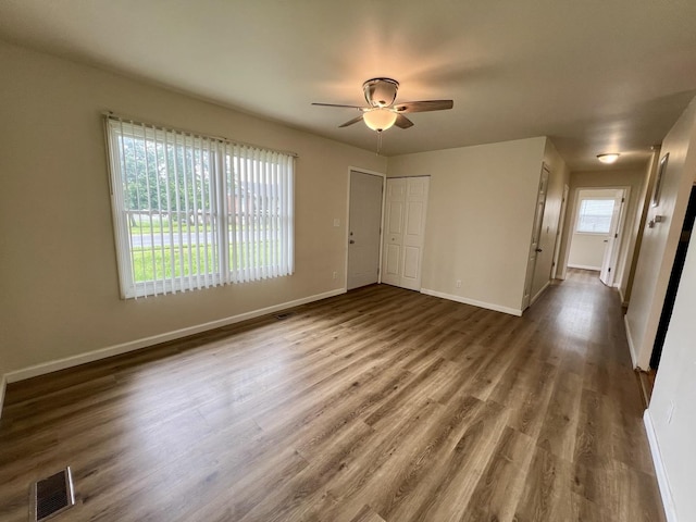 2422 E Washington St, Urbana, IL 61802 - unfurnished bedroom with wood finished floors, a closet, and a ceiling fan