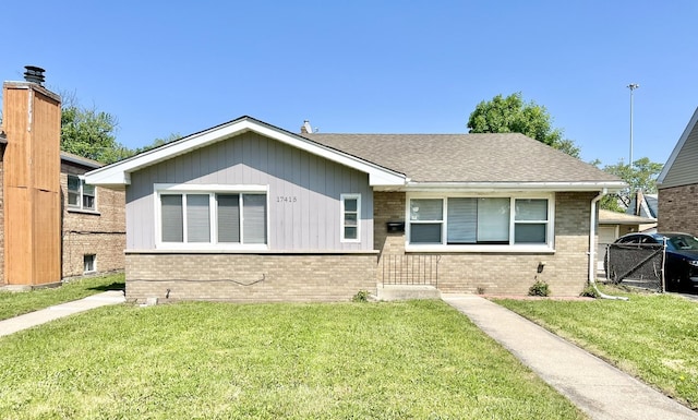 17415 Burnham Ave, Lansing, IL 60438 - ranch-style home with brick siding, a front lawn, and a shingled roof