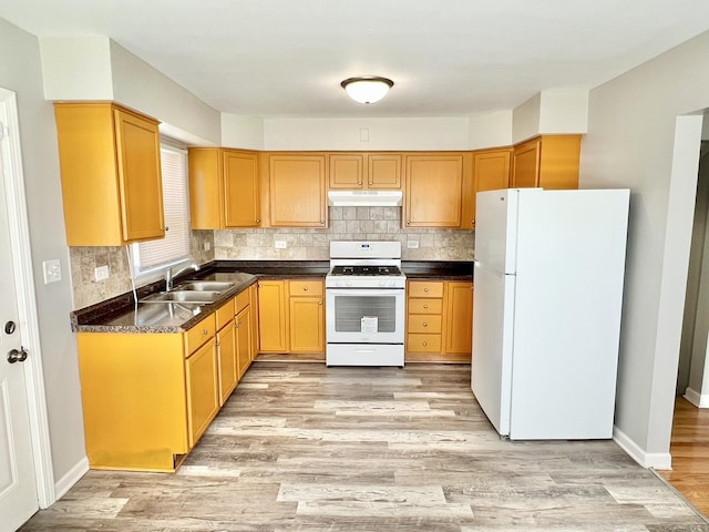 17415 Burnham Ave, Lansing, IL 60438 - kitchen with white appliances, under cabinet range hood, a sink, light wood-style floors, and dark countertops