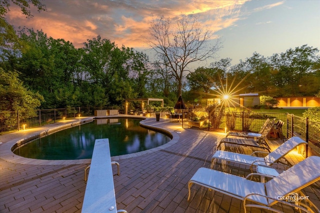 5N477 Curling Pond Rd, Wayne, IL 60184 - pool at dusk with a diving board, a patio area, an outdoor fire pit, and view of scattered trees