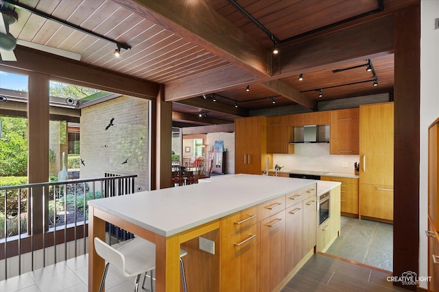 5N477 Curling Pond Rd, Wayne, IL 60184 - kitchen featuring rail lighting, wall chimney exhaust hood, a wooden ceiling with exposed beams, light countertops, and a kitchen island