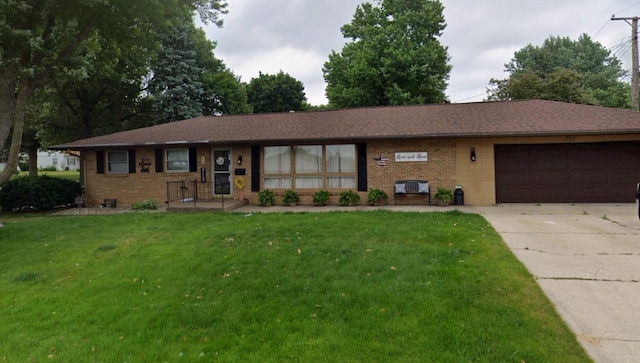 113 Maple Ave, Mount Morris, IL 61054 - ranch-style home with brick siding, concrete driveway, an attached garage, and a front yard
