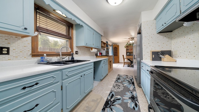 113 Maple Ave, Mount Morris, IL 61054 - kitchen featuring blue cabinetry, a sink, decorative backsplash, stainless steel appliances, and light countertops