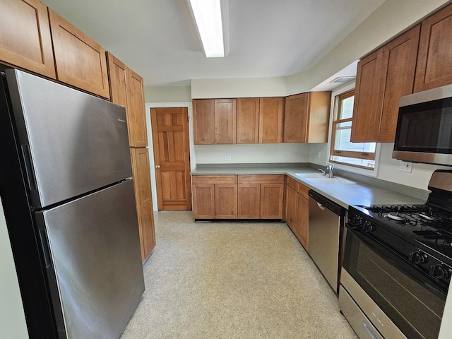 5S426 Columbia St, Naperville, IL 60563 - kitchen with appliances with stainless steel finishes, a sink, brown cabinetry, light countertops, and light floors