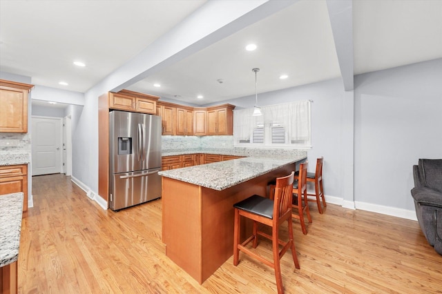 5642 W Dakin St, Chicago, IL 60634 - kitchen featuring stainless steel fridge with ice dispenser, decorative backsplash, a breakfast bar, light wood-style floors, and recessed lighting