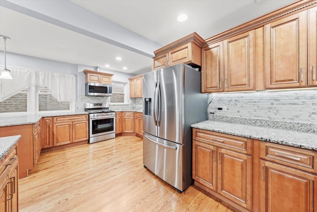 5642 W Dakin St, Chicago, IL 60634 - kitchen with stainless steel appliances, tasteful backsplash, light wood-style flooring, light stone counters, and decorative light fixtures