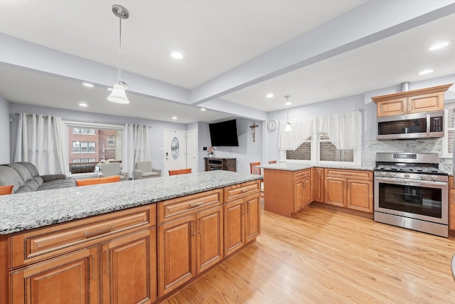 5642 W Dakin St, Chicago, IL 60634 - kitchen with appliances with stainless steel finishes, open floor plan, light wood finished floors, light stone counters, and pendant lighting