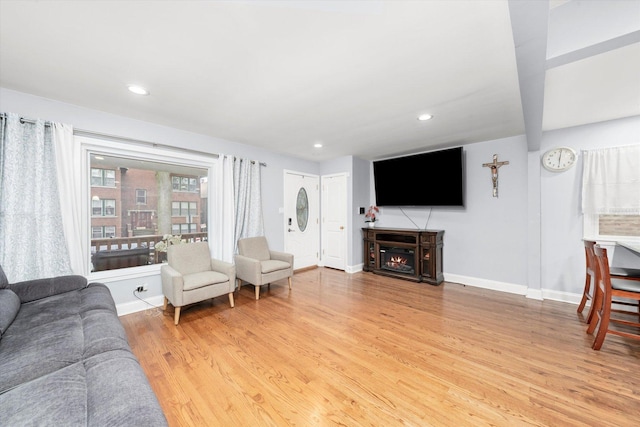 5642 W Dakin St, Chicago, IL 60634 - living room with light wood-style flooring, baseboards, a warm lit fireplace, and recessed lighting