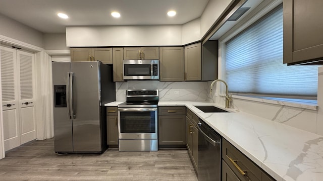 8210 Elmwood Ave Unit 106, Skokie, IL 60077 - kitchen featuring stainless steel appliances, a sink, light wood-type flooring, light stone counters, and recessed lighting