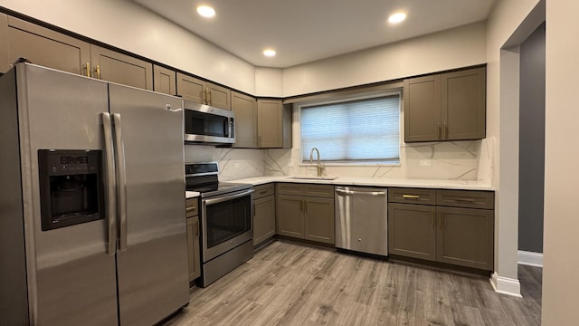 8210 Elmwood Ave Unit 106, Skokie, IL 60077 - kitchen with stainless steel appliances, a sink, light wood-style floors, backsplash, and recessed lighting