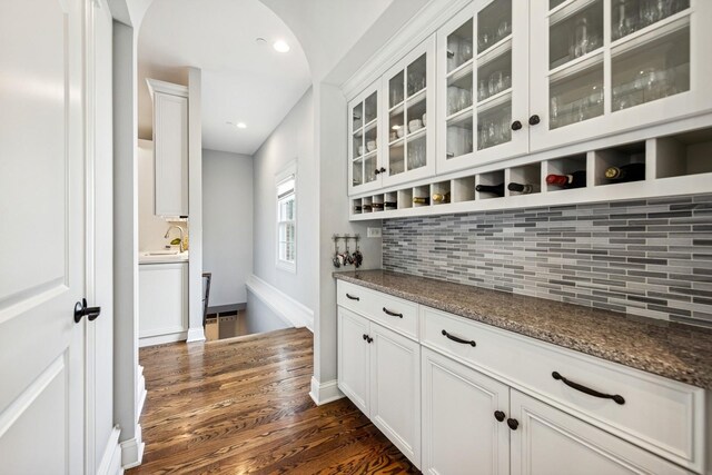 16 Tuttle Ave, Clarendon Hills, IL 60514 - bar area with decorative backsplash, dark wood finished floors, arched walkways, baseboards, and a sink