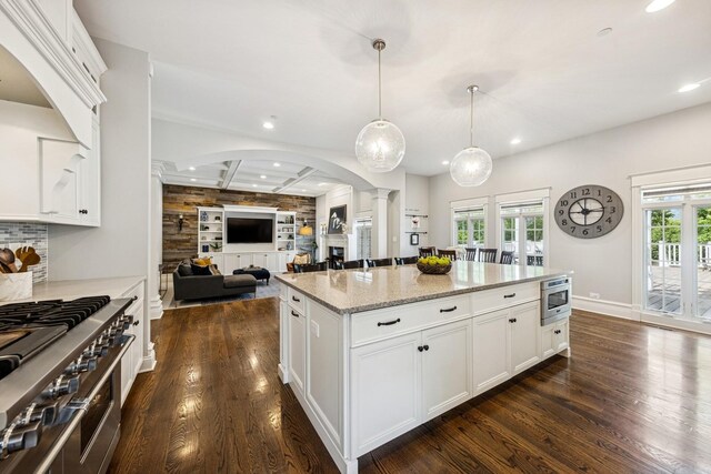 16 Tuttle Ave, Clarendon Hills, IL 60514 - kitchen with ornate columns, arched walkways, recessed lighting, dark wood-style floors, and light stone countertops