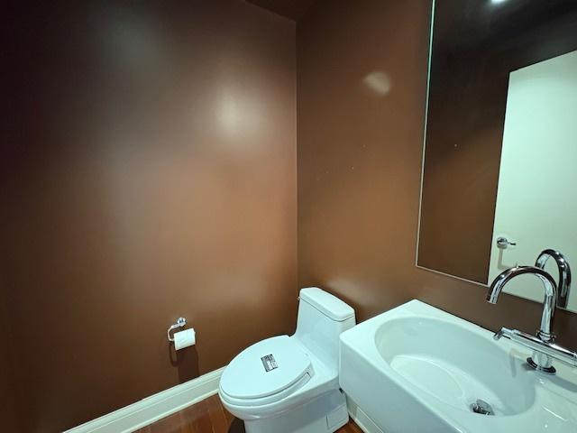 270 E Pearson St Unit 602, Chicago, IL 60611 - bathroom featuring a sink, toilet, and baseboards