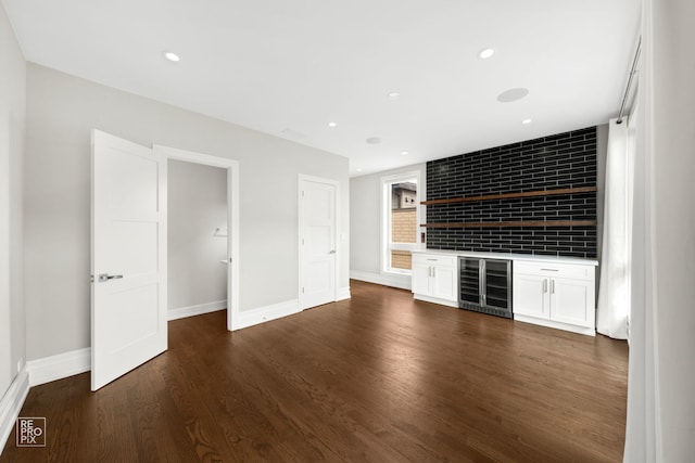 1448 W Chestnut St Unit 3, Chicago, IL 60642 - unfurnished living room featuring wine cooler, a bar, baseboards, dark wood-style floors, and recessed lighting