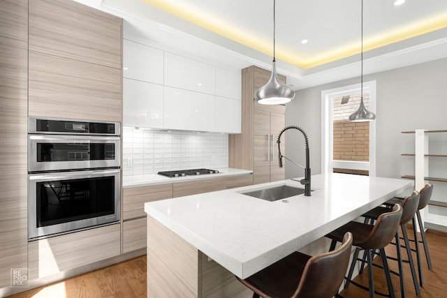 1448 W Chestnut St Unit 3, Chicago, IL 60642 - kitchen with modern cabinets, a sink, stainless steel double oven, wood finished floors, and recessed lighting