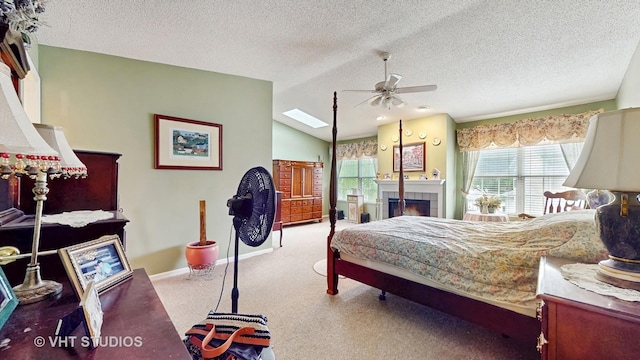 1719 Westbridge Ct, Hoffman Estates, IL 60194 - carpeted bedroom with a textured ceiling, a tiled fireplace, baseboards, lofted ceiling, and a skylight