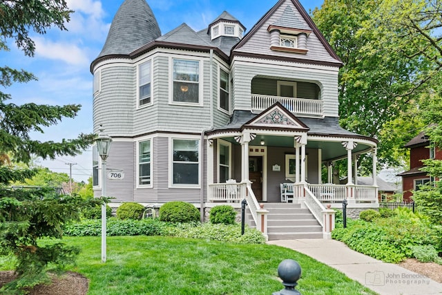 706 Douglas Ave, Elgin, IL 60120 - victorian house with covered porch, a front yard, and a balcony
