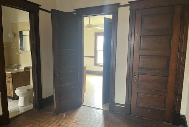 1825 S 6th St, Rockford, IL 61104 - unfurnished bedroom featuring wood finished floors, ensuite bath, a sink, and baseboards
