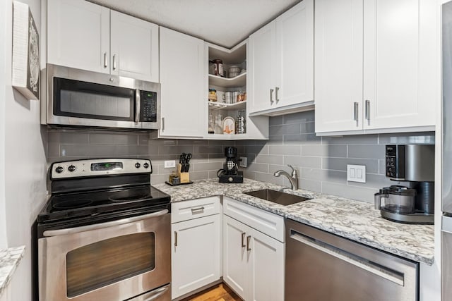 480 N Mcclurg Ct Unit 807, Chicago, IL 60611 - kitchen featuring appliances with stainless steel finishes, a sink, white cabinets, and light stone countertops