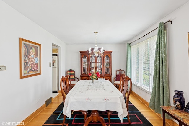 5738 W 88th St, Oak Lawn, IL 60453 - dining space with a chandelier, light wood-style flooring, and baseboards