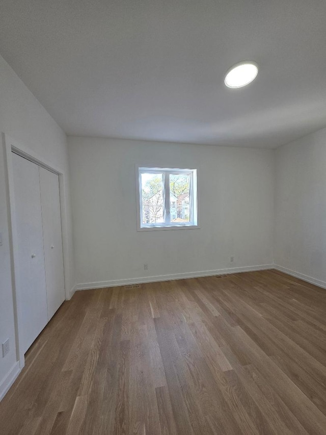 2906 W 40th St, Chicago, IL 60632 - unfurnished bedroom with wood finished floors, baseboards, and a closet