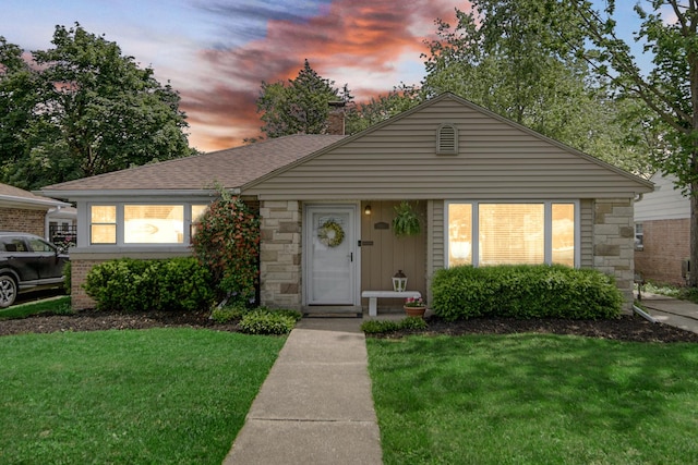 17601 Howe Ave, Homewood, IL 60430 - view of front of house with a front yard, a shingled roof, and stone siding