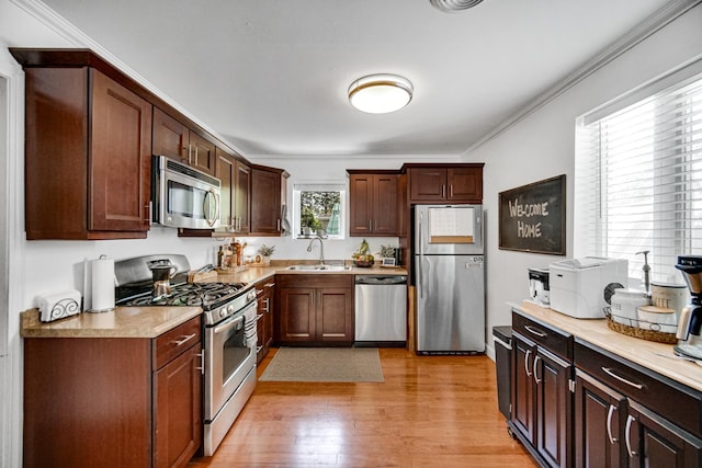 17601 Howe Ave, Homewood, IL 60430 - kitchen with stainless steel appliances, light wood-type flooring, a sink, light countertops, and crown molding