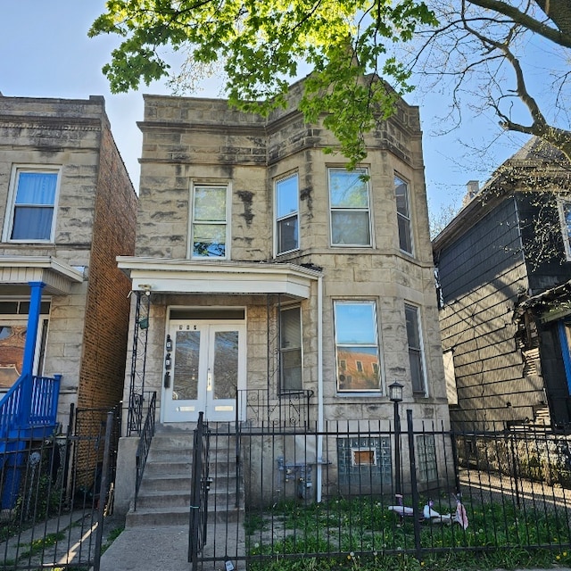 212 N Leamington Ave, Chicago, IL 60644 - view of front facade with stone siding, french doors, a fenced front yard, and a gate