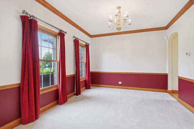 548 Asbury Dr, Aurora, IL 60502 - spare room featuring a chandelier, ornamental molding, arched walkways, carpet flooring, and baseboards