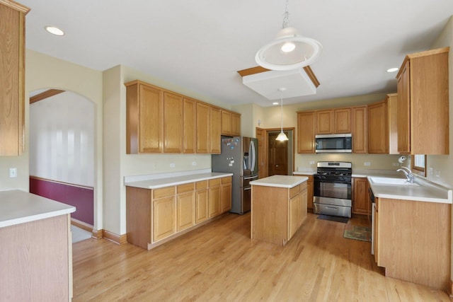 548 Asbury Dr, Aurora, IL 60502 - kitchen with stainless steel appliances, arched walkways, a kitchen island, light countertops, and light wood-style floors