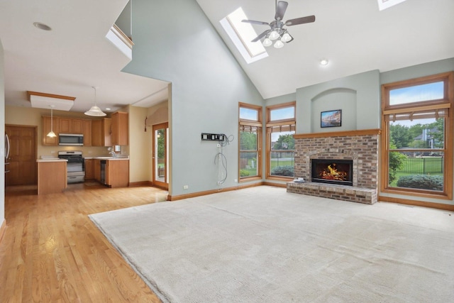 548 Asbury Dr, Aurora, IL 60502 - unfurnished living room with high vaulted ceiling, healthy amount of natural light, a sink, a skylight, and a brick fireplace