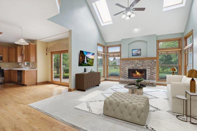 548 Asbury Dr, Aurora, IL 60502 - living area with high vaulted ceiling, a ceiling fan, a skylight, a fireplace, and light wood-style floors