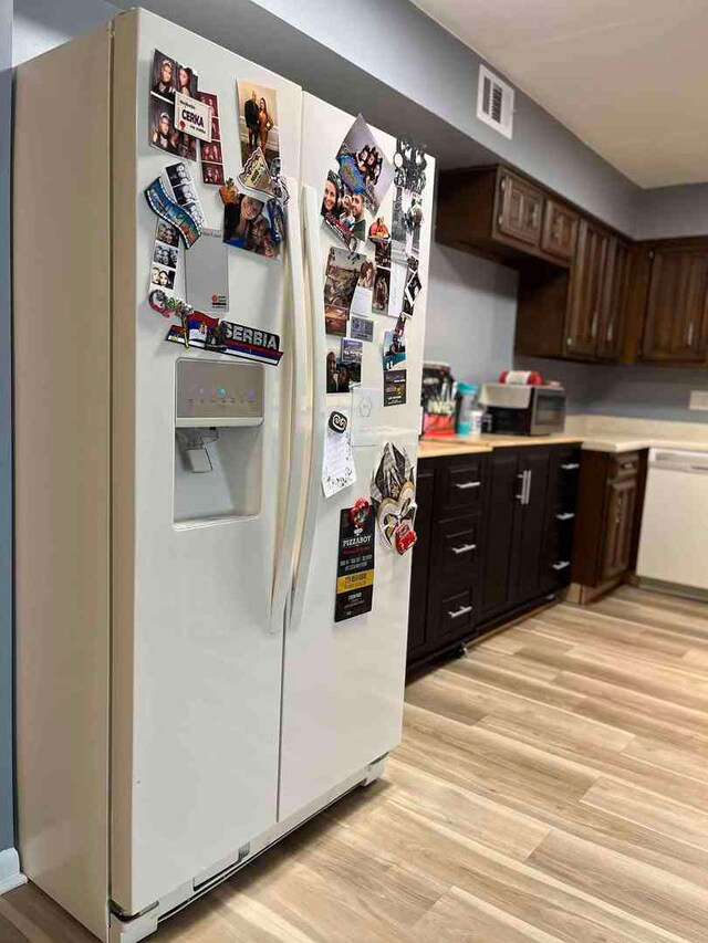 900 S River Rd Unit 3A, Des Plaines, IL 60016 - kitchen with white appliances, a sink, light countertops, baseboards, and light wood-style flooring