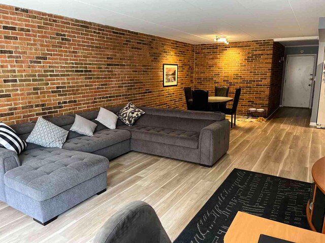 900 S River Rd Unit 3A, Des Plaines, IL 60016 - living room featuring brick wall and wood finished floors