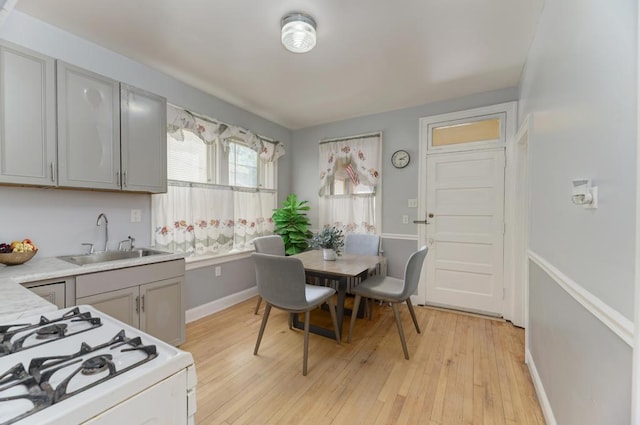 6834 S Rockwell St, Chicago, IL 60629 - kitchen with a sink, gas range gas stove, light countertops, light wood-style flooring, and baseboards