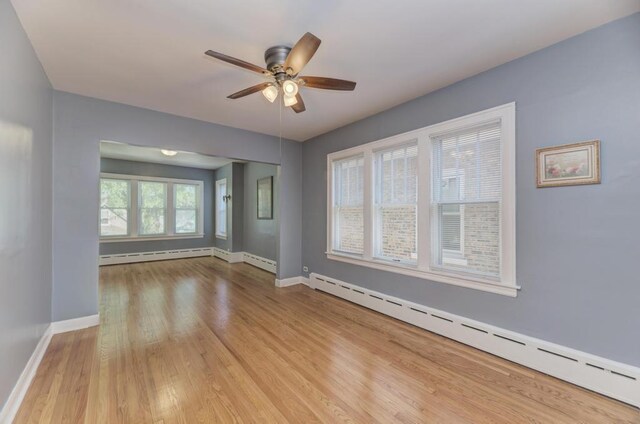6834 S Rockwell St, Chicago, IL 60629 - unfurnished room featuring a baseboard heating unit, a ceiling fan, and wood finished floors