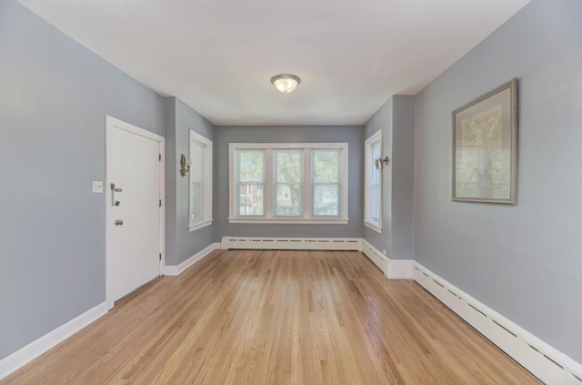 6834 S Rockwell St, Chicago, IL 60629 - spare room featuring light wood-style floors, baseboards, a baseboard heating unit, and a baseboard radiator
