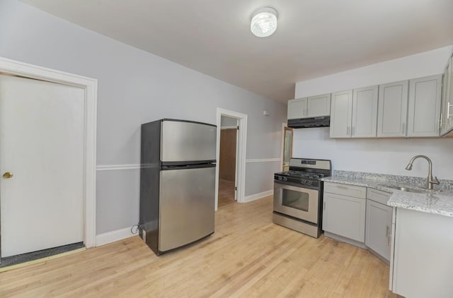6834 S Rockwell St, Chicago, IL 60629 - kitchen with stainless steel appliances, under cabinet range hood, a sink, gray cabinetry, and light stone countertops