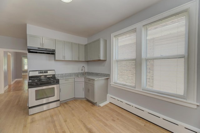 6834 S Rockwell St, Chicago, IL 60629 - kitchen with stainless steel gas range oven, a baseboard heating unit, under cabinet range hood, a sink, and gray cabinetry