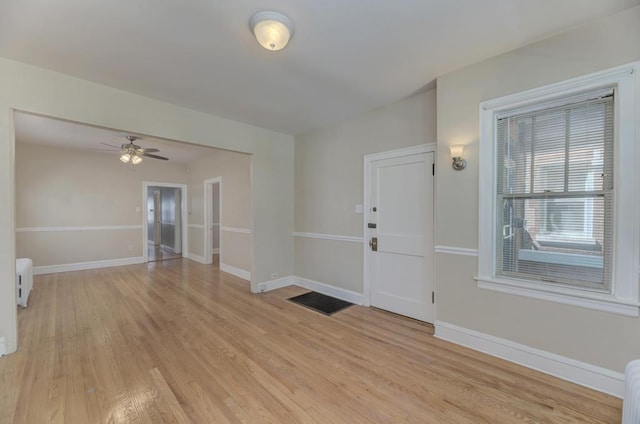 6834 S Rockwell St, Chicago, IL 60629 - empty room featuring radiator heating unit, light wood-type flooring, baseboards, and a ceiling fan