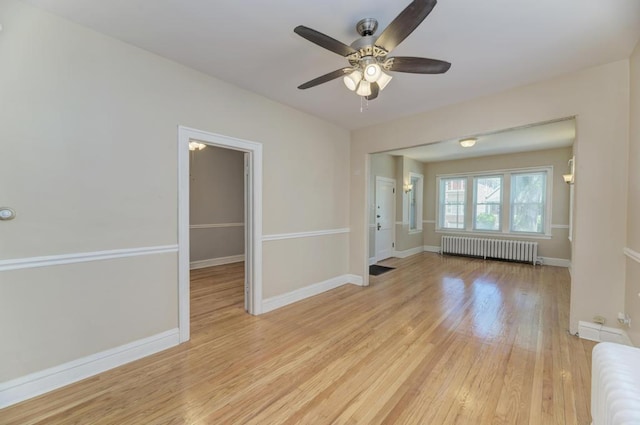 6834 S Rockwell St, Chicago, IL 60629 - empty room with radiator heating unit, light wood-type flooring, a ceiling fan, and baseboards