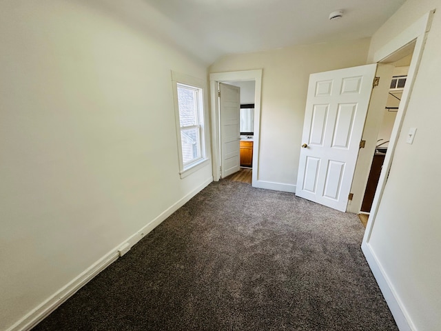 220 S Entrance Ave, Kankakee, IL 60901 - unfurnished bedroom with dark carpet, baseboards, and vaulted ceiling