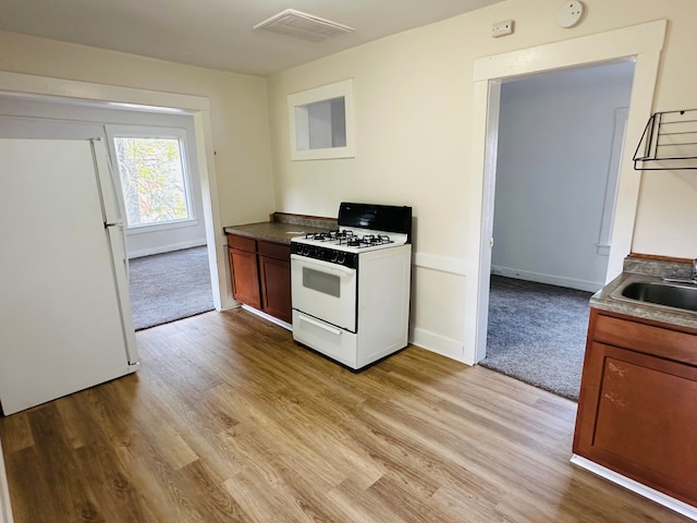 220 S Entrance Ave, Kankakee, IL 60901 - kitchen featuring white appliances, a sink, light wood-style floors, and baseboards
