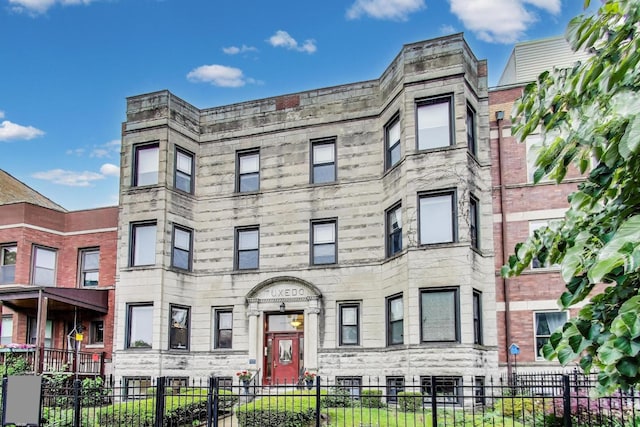 4440 N Dover St Unit Gs, Chicago, IL 60640 - view of front of house with stone siding and a fenced front yard