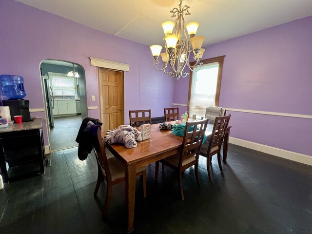 335 N Highway Ave, Deland, IL 61839 - dining area with a chandelier, baseboards, dark wood-style floors, and arched walkways