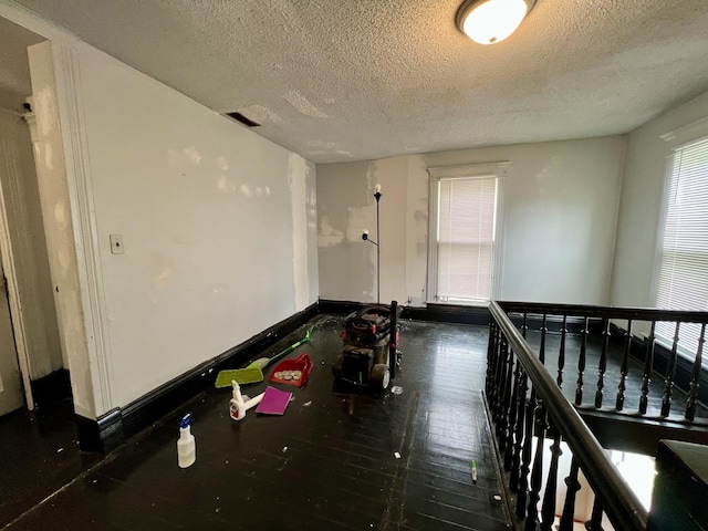 335 N Highway Ave, Deland, IL 61839 - hallway featuring a textured ceiling, baseboards, and wood finished floors