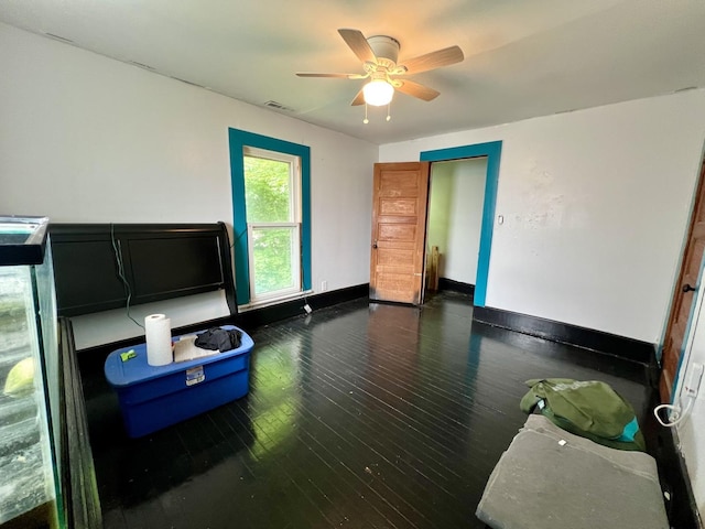 335 N Highway Ave, Deland, IL 61839 - unfurnished bedroom with wood-type flooring, baseboards, and ceiling fan
