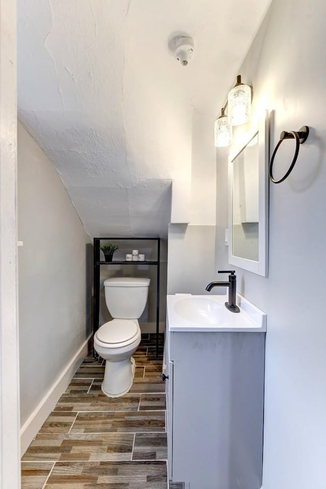614 E 92nd Pl, Chicago, IL 60619 - half bath with vanity, wood finished floors, toilet, lofted ceiling, and baseboards
