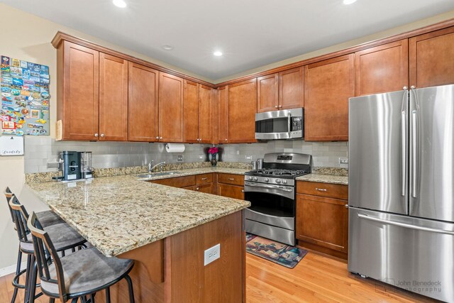 2127 Apple Hill Ln, Buffalo Grove, IL 60089 - kitchen featuring stainless steel appliances, brown cabinets, light wood finished floors, and recessed lighting